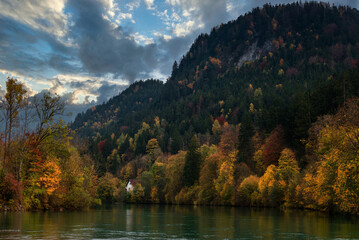 Wall Mural - Wonderful landscape of mountain village in fall. View of forest with yellowed foliage, which reflects in water. Fussen. Lech river. Bavaria. Germany.