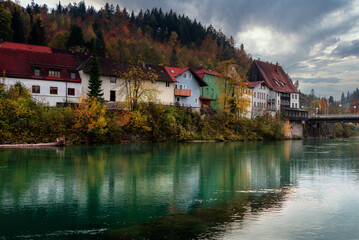 Wall Mural - Wonderful landscape of mountain village in fall. View of forest with yellowed foliage, which reflects in water. Fussen. Lech river. Bavaria. Germany.