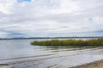 bay with sand and grass at Jamaica bay wildlife refuge with nyc background