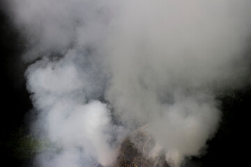 White smoke thick from the fire. Two large smoke pipes form swirls.