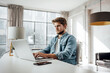 © Rymden - Young man typing on laptop. Modern businessman at sunny office. Freelancer at work. Blogger or journalist writing new post