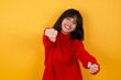 © Roquillo - Caucasian brunette woman wearing red casual sweater isolated over yellow background  imagine steering wheel helm rudder passing driving exam good mood fast speed