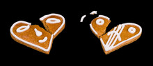 Two Broken Gingerbreads In Heart Shape With Painted Smiley Isolated On Black Background. Close-up Of Cracked Baked Holiday Pastries Decorated By Smiling And Sad Emoticon. Damaged Aromatic Xmas Sweets.