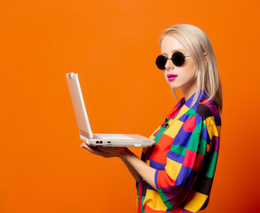 Wall Mural - Style blonde in 90s clothes with notebook computer