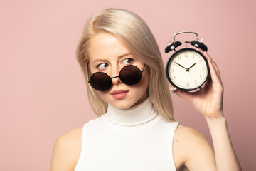 Wall Mural - Style blonde in top and sunglasses with alarm clock