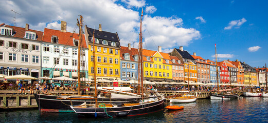 Wall Mural - Copenhagen, Denmark-2 August, 2019: Famous Nyhavn (New Harbour) bay in Copenhagen, a historic European waterfront with colorful buildings. A starting point for boat and canal tours