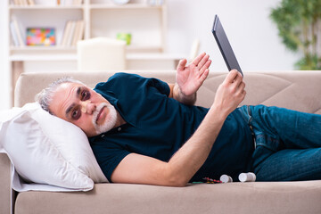 Wall Mural - Old man with injured eyes resting at home