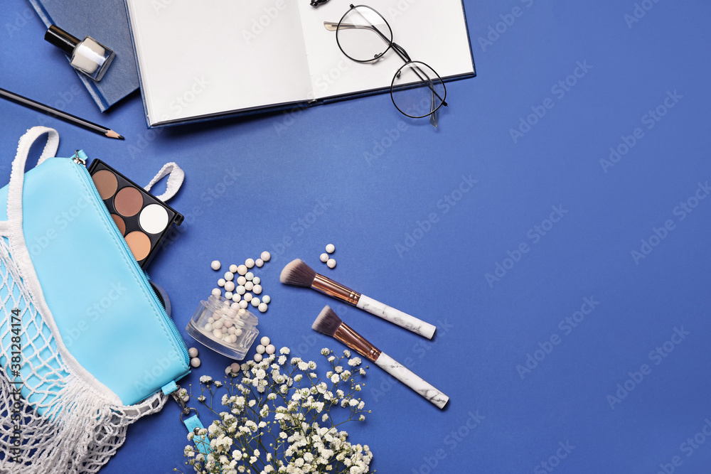 Makeup bag with decorative cosmetics and accessories on color background