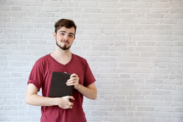 Wall Mural - Young man wear a red shirt holding a bible.