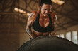© Jacob Lund - Strong woman performing tyre flipping workout