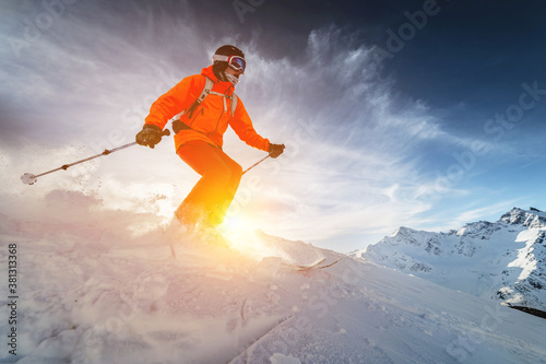 Plakaty Narciarstwo  czlowiek-narciarz-freerider-jedzie-z-predkoscia-w-sniegu-w-puchu-ze-stoku-na-tle-s