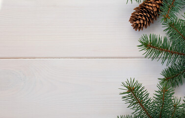 Christmas fir tree with pinecones on a white wooden board and copy space for your text. Banner.Flat lay