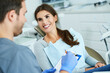 © Kalim - Male dentist and woman in dentist office