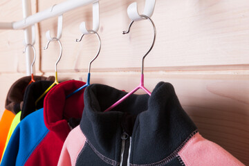 Wall Mural - Colorful fleece jackets are on a rack, close-up photo