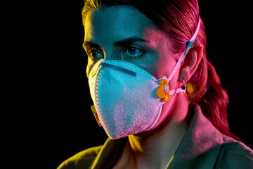 Wall Mural - health, safety and pandemic concept - close up of young woman wearing protective mask or respirator over black background