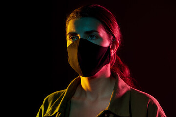 Poster - health, safety and pandemic concept - young woman wearing reusable protective mask over black background