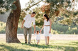 © Andriy Medvediuk - happy Family walking in the park holding hands and smiling. mom, dad and son spending time together outdoor on a summer day. selective focus