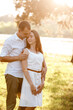 © Andriy Medvediuk - beautiful young couple are hugging in the summer park. stylish man and woman having fun outdoors. family day concept. copy space.