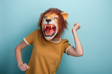 Young Woman In Lion Mask Perform Carefree Dance Moves, Isolated On Blue Background.