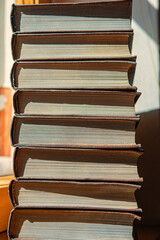 Wall Mural - stack of books on the background of the wall in the library illuminated by sunlight.