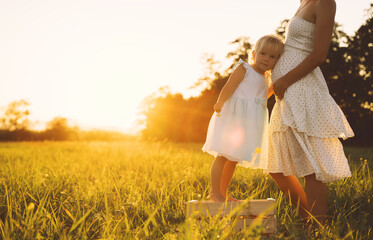 Wall Mural - Young pregnant mother and daughter on nature outdoors.