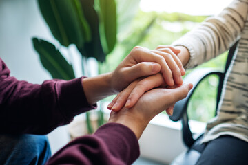 Wall Mural - A man and a woman holding each other hands for comfort and love