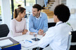 © Drazen - Happy couple talking while having appointment with a doctor at the clinic.