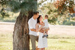 © Andriy Medvediuk - dad, mom hugging son outdoors in the park. The concept of summer holiday. Mother's, father's, baby's day. Family spending time together on nature. Family look. selective focus