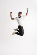 Photo of jumping while dancing african american guy in headphones jumping while dancing