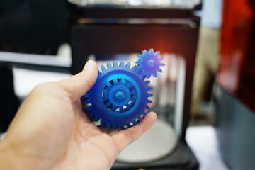 hand with Object of gear printed on 3d printer close-up
