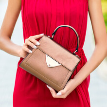 Dressed In Red Woman Holding A Luxury Handbag