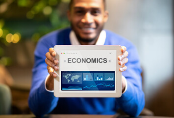 Poster - Black Businessman Showing Digital Tablet With Economics Graphs Sitting Indoors