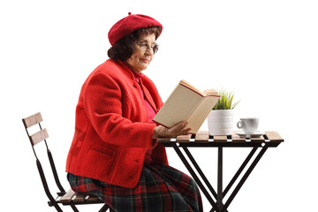 Canvas Print - Mature woman at a cafe table reading a book