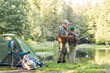 © Seventyfour - Back view full length portrait of loving father teaching son fishing while enjoying camping trip together, copy space
