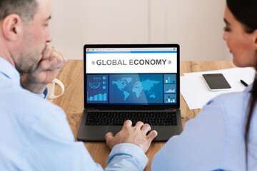 Poster - Businessman And Businesswoman Working On Laptop With Statistics Data Indoor