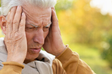 Poster - Portrait of senior man in park with headache