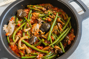 Healthy stir fry vegetables, green beans, mushrooms in an iron pot and wooden table