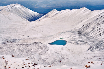 Moraine lake in the upper reaches of a mountain gorge after a recent snowfall; purity of water resources concept