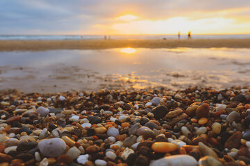 Sunlights on stone beach with view of sunset