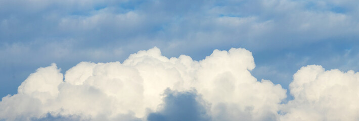 Panorama of blue sky with bright white cumulus clouds