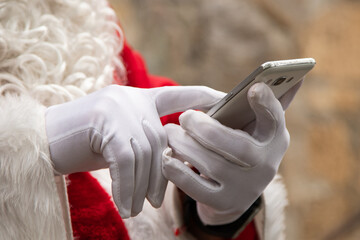 closeup of santa claus hands with mobile phone