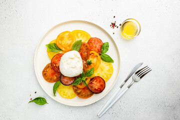 Poster - Delicious caprese salad with ripe colorful tomatoes and mozzarella cheese with fresh basil leaves. Italian food, top view