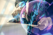 © peshkova - Double exposure of man's hands holding and using a digital device and forex graph drawing. Financial market concept.