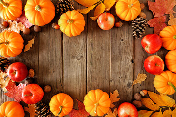 Poster - Autumn frame with pumpkins, leaves and apples. Overhead view on a rustic dark wood background with copy space.