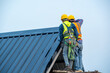 © visoot - Construction worker wearing safety harness and safety line install new roof.