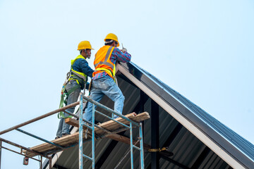 Poster - Construction worker wearing safety harness and safety line install new roof.