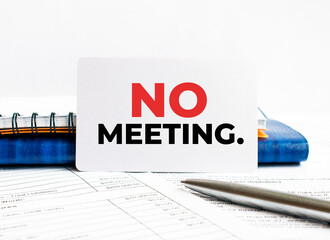 Business card with text No meeting lying on blue notebook