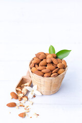 Wall Mural - Almond nuts in basket isolated on white wooden background, Almonds are healthiest nuts and one of the best brain foods.Selective focus.