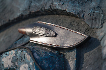 Knife in a sheath on a stone background