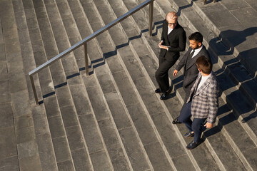 high angle view of business team moving down the stairs together in the city